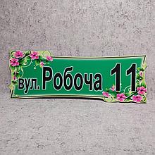 Указатель улицы нестандартной формы с красными цветами