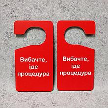 Двусторонняя табличка-крючок на ручку двери "Извините. Идёт процедура" (Красный фон)